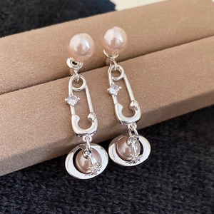 Vue macro de boucles d'oreilles épingle à nourrice avec perles roses et orbes