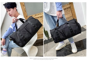 Man carrying a black large capacity nylon fitness bag with shoulder strap and handles