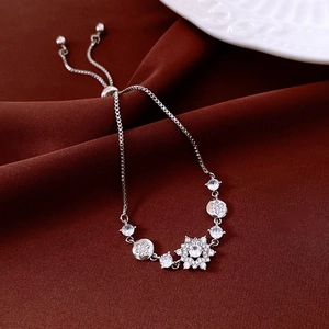Macro shot of silver zircon flower pendant and adjustable slider clasp detail on bracelet