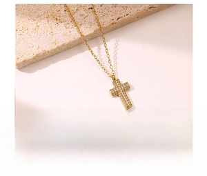 Close-up of gold titanium steel cross necklace with micro-pave white zircon stones