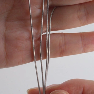 Detailed view of polished silver metal snake chains showing texture and flexibility