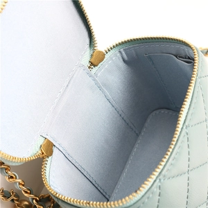 Detail view of the mint green quilted leather interior with gold zipper and chain strap
