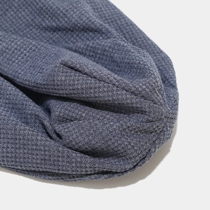 Détail du haut d'un bonnet bleu marine avec maille gaufrée et coutures de finition