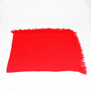 Vista dettagliata della sciarpa quadrata rossa lavorata a maglia con frange decorative