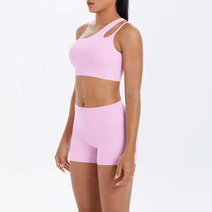 Close-up of pink one-shoulder yoga set with cutout detail and high-waist fitness shorts