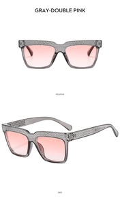 Detail of luxury square sunglasses with grey frames, pink gradient lenses and rhinestones