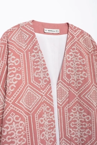 Close-up of pink cardigan with white embroidery detail and brand size label EUR M