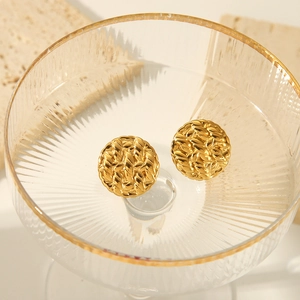 Detailaufnahme goldener runder Ohrstecker mit Hammerschlag-Struktur in luxuriösem Design