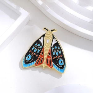Detailed view of a vintage enamel moth brooch with intricate geometric wing patterns