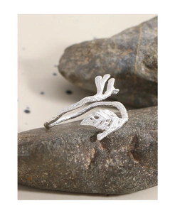 Macro detail of silver leaf branch ring with hammer texture on natural grey stone