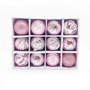 Close-up of pink Christmas ornaments with glitter, matte, and swirl textures in a box