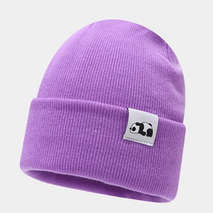 Close-up of purple knit beanie featuring a white woven label with black panda icon