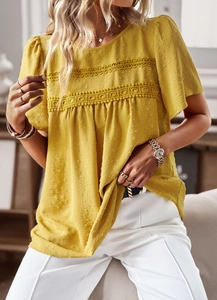 Detailed close-up of yellow crew neck top featuring Swiss dot texture and lace stitching
