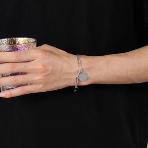 Bracelet double chaîne en acier titane avec pendentif rond porté par un mannequin