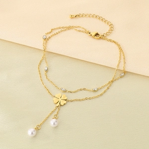 Detail of gold clover anklet featuring delicate pearls, tassels, and sparkling crystals
