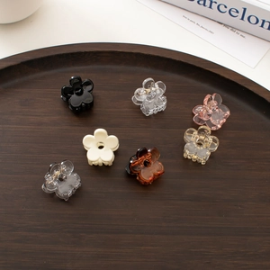 Mini floral hair clips in transparent and assorted colors displayed on a wood tray