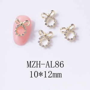 Dettaglio di un charm per unghie a fiocco dorato con strass da 10x12mm per manicure