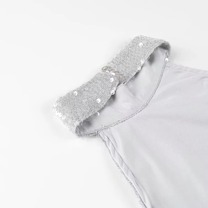 Detailaufnahme des grauen Neckholder-Kleidausschnitts mit silbernen Paillettenträgern