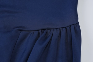 Macro shot of fine ruched texture and stitching on a deep blue backless summer dress
