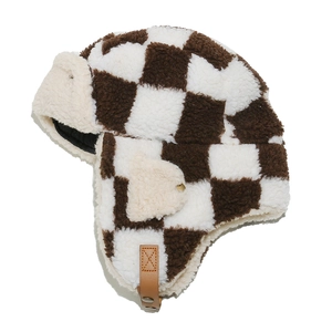 Detailed top view of checkered plush trapper hat with brown faux leather strap