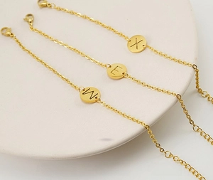 Detail of vacuum gold-plated stainless steel initial letter pendants on cross chains