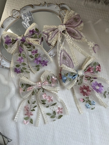 Macro detail of intricate lace floral embroidery on large butterfly hair bow streamers