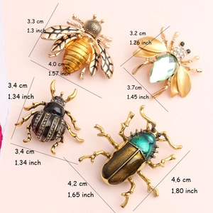 Detailed size chart showing insect brooches with dimensions in cm and inches