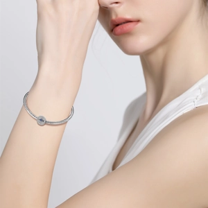 Detail of S925 sterling silver evil eye charm bracelet with sparkling zircon on wrist