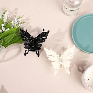 Detail view of large butterfly hair claws in black and cream on a decorative tray
