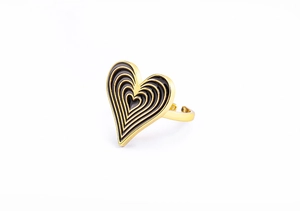 Detailed macro of a 18K gold-plated heart ring with layered black enamel concentric circles