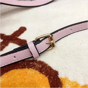 Detail of adjustable pale pink PU leather shoulder strap with gold metal buckle