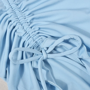 Détail du tissu tricoté bleu clair montrant les fronces à cordon et les plis texturés