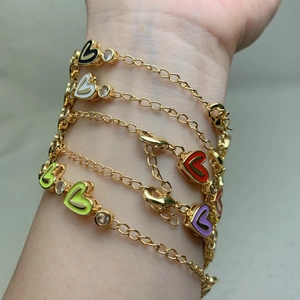 Golden heart charm bracelets with multicolored enamel hearts and zircon accents on wrist