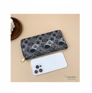 Detail of a large capacity long wallet with black and white pattern and zipper closure