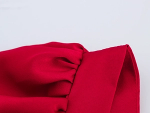 Detail van rode jurk met pofmouwen met geplooid ontwerp en hoogwaardige stikselkwaliteit