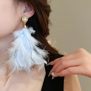 Detail of elegant gold earring featuring a large pearl and soft blue fluffy feather pendant