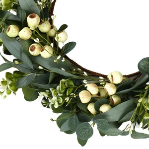 Artificial eucalyptus wreath with white berries and flowers on a brown rattan base