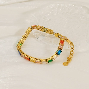Elegant gold bracelet with multicolored zircon stones on a decorative ice-like tray
