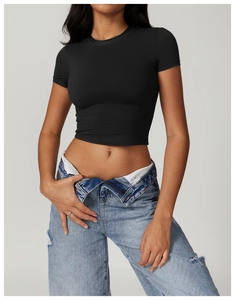 Detail of slim fit black cropped sports t-shirt with crew neck and folded denim jeans