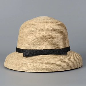 Close-up of fine raffia straw texture and elegant black mesh bow on this sun hat