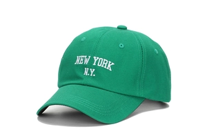 Détail de la broderie blanche New York et des coutures sur une casquette en coton vert vif