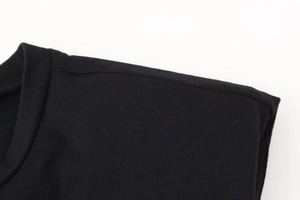 Detail of shoulder seams and round neckline on a black padded shoulder knit t-shirt