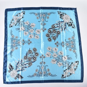 Close-up of floral print satin square scarf with light blue base and navy blue border