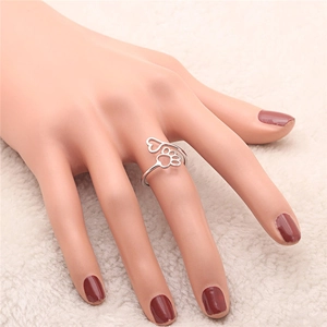 Detail of silver open ring with hollow heart and dog paw prints worn on hand