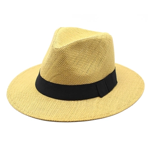 Close-up of yellow woven straw sun hat with classic wide black ribbon and side knot detail
