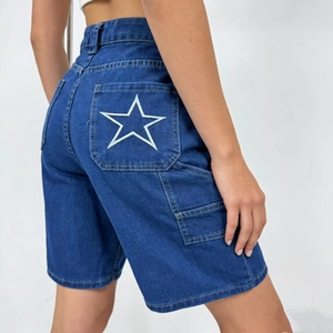 Dettaglio del ricamo a stella bianca sulla tasca posteriore dei pantaloncini in denim blu