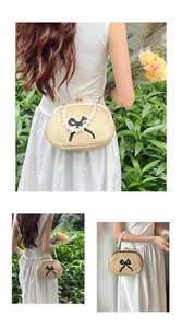 Détail du sac en paille avec anse en perles, nœud noir et fermoir métallique chic