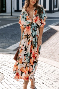 Detail of bohemian deep V-neck maxi dress with vibrant orange floral patterns in chiffon