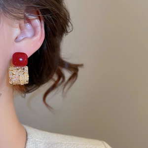 Gros plan de boucles d'oreilles vintage en zircon rouge et plaqué or sur mannequin