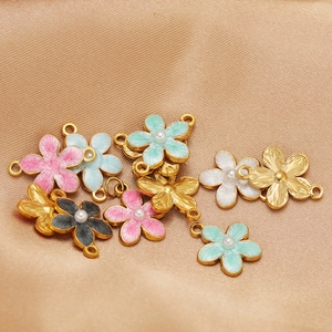 Enamel flower pendants with imitation pearls in multiple colors on textured fabric